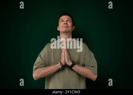 Homme debout devant le mur vert Banque D'Images