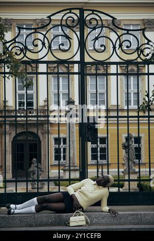 Jeune femme noire blonde dehors. Elle est en polo jaune, chaussettes blanches Banque D'Images