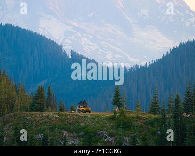 Camion jaune Overlanding camping sur la falaise près du Mt. Rainier, Washington Banque D'Images