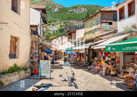 Vue sur la rue piétonne avec des boutiques de souvenirs et des cafés en plein air dans Stari Bar. Monténégro Banque D'Images