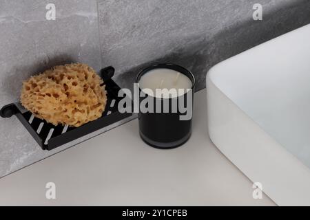 Porte-éponge moderne et bougie dans la salle de bains minimaliste Banque D'Images