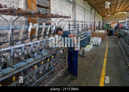 Machines pour faire tourner de petites bobines de fil ou de fil en bobines plus grandes. Hilandería Warmi, une usine de tissage à Palpalá, Argentine. Banque D'Images