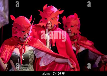 Dans des masques, des manteaux et des cagoules rouges vifs une performance colorée de la comédie The Scarlet Pipistrelle à Noël 2018 au Seckford Theatre Woodbridge Banque D'Images