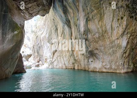 Une grande grotte avec une rivière bleue qui la traverse. La grotte est très grande et l'eau est très claire Banque D'Images