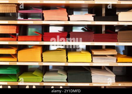 Présentoir vibrant et coloré d'enveloppes et de papeterie soigneusement disposés sur les étagères d'un magasin créatif Banque D'Images