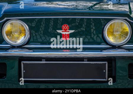 Lisbonne, Portugal - 20 janvier 2024 : gros plan de la vue avant de la grande randonneuse V8 Vantage vert foncé classique Aston Martin, connue comme la première supercar britannique, avec l'emblème de l'AMOC, la célébration des 75 ans de l'Aston Martin Owners Club en 2010 et une calandre unique Banque D'Images