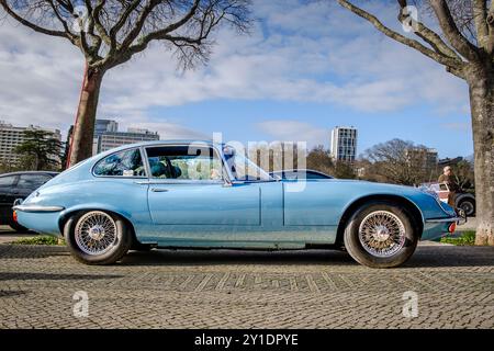 Lisbonne, Portugal - 20 janvier 2024 : vue latérale complète de la Jaguar type E-type 3 coupé classique bleu clair avec détails chromés stationné sur un chemin pavé près de Green Park. Banque D'Images
