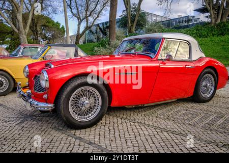 Lisbonne, Portugal - 20 janvier 2024 : Vintage rouge Austin Healey 100-6 Roadster sur pavé près du parc vert Banque D'Images