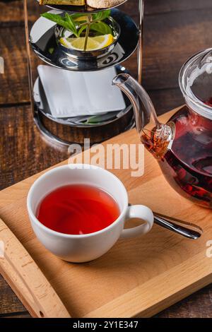 Tisane saine brassée à partir d'herbes rouges et de fruits dans une tasse en porcelaine blanche Banque D'Images