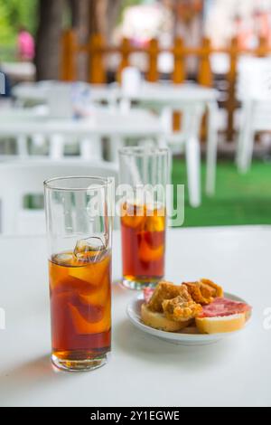 Apéritif espagnol : deux verres de vermouth et tapa dans une terrasse. L'Espagne. Banque D'Images