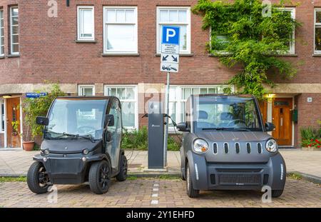 Amsterdam, pays-Bas, 28.08.2024, deux petits véhicules électriques en cours de charge sur le parking ev station de charge Banque D'Images