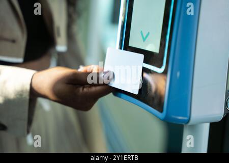 Jeune femme méconnaissable payant Conctactless dans City train Banque D'Images