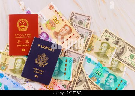 Il symbolise la confrontation entre les économies de la Chine, des États-Unis lorsque les passeports authentiques sont présentés avec la monnaie chinoise, le yuan, les billets de banque en dollars américains de différentes coupures. Banque D'Images