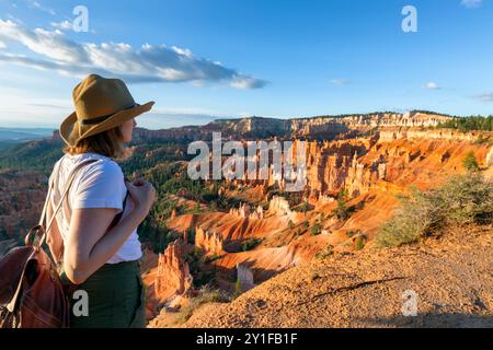 Femme heureuse sur le sentier dans un paysage naturel magnifique avec des hoodoos, des pinacles et des flèches rocheuses dans le parc national de Bryce Canyon, Utah Banque D'Images