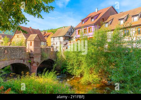 Maisons médiévales colorées à colombages près du pont fortifié et du canal de la rivière Weiss dans le centre-ville historique de Kaysersberg vignoble, France. Banque D'Images