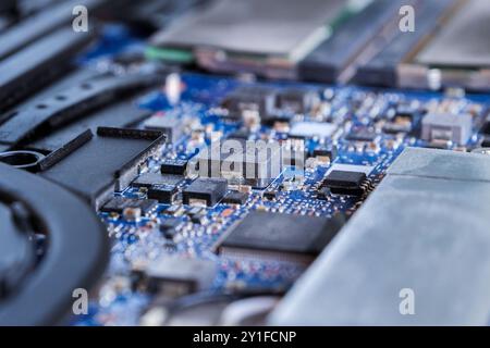 Macro-plan détaillé de micropuces sur une carte de circuit imprimé bleue mettant en valeur la technologie moderne Banque D'Images