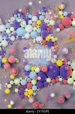 Composition d'art abstrait colorée avec des sphères vibrantes dans un motif tourbillonnant sur un fond gris Banque D'Images