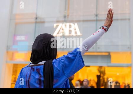 Leeds, Royaume-Uni. 06 SEPTEMBRE, 2024. Un activiste tient la main en l'air devant le magasin de vêtements "Zara", une cible du boycott palestinien avec des acvistes qui organisent un "die-in" sur Briggate dans le centre-ville de Leeds, des activistes pro-palestiniens, certains ornés de gommages d'hôpital, se couvrent de faux sang et sont restés immobiles sur le sol alors que l'audio des multiples attentats ainsi que des interviews avec des enfants de Gaza ont été joués sur un orateur. Crédit Milo Chandler/Alamy Live News Banque D'Images