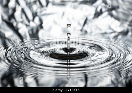 une goutte d'eau saute de la surface de l'eau Banque D'Images