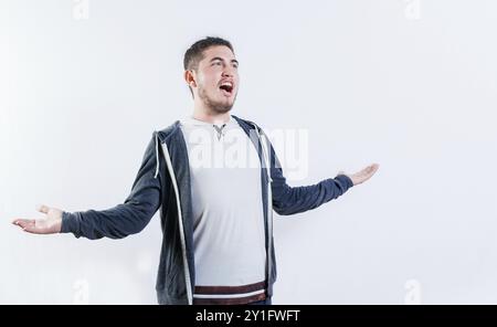 Jeune homme en colère criant les mains ouvertes isolé. Gars agacé à bras ouverts criant isolé Banque D'Images