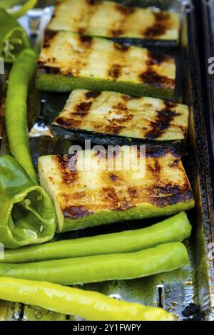 Courgettes grillées et poivrons verts avec des bandes de grillades sur un barbecue Banque D'Images