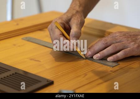 Mains utilisant une règle et dessinant des lignes sur le bois en gros plan Banque D'Images