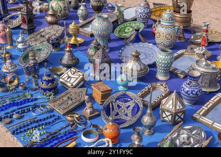 Une scène de marché marocaine colorée le long d'une rue animée, avec des vendeurs vendant des épices, des textiles et des produits artisanaux Banque D'Images