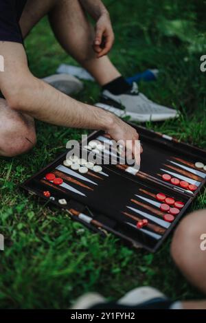 Amis jouant au backgammon en plein air par une journée ensoleillée dans le parc Banque D'Images