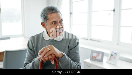 Homme senior, maison et pensée avec bâton de marche, bague de mariage et chagrin le matin avec la mémoire du partenaire. Réflexion, retraite et personne âgée Banque D'Images