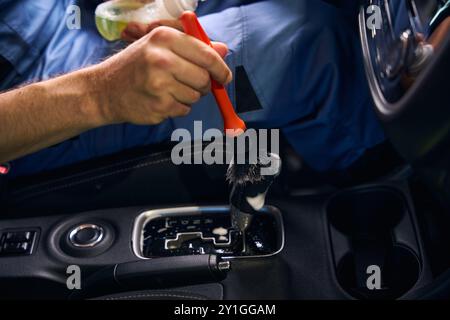 Guy nettoie les petites pièces à l'intérieur de la voiture Banque D'Images