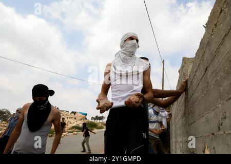 Les manifestants palestiniens affrontent les forces de sécurité israéliennes dans la ville de Kafr Qaddum en Cisjordanie alors que l'armée israélienne tente de réprimer leur manifestation hebdomadaire contre le mur de séparation israélien, la confiscation de leurs terres, la colonie israélienne voisine de Kadumin et la fermeture de la route principale de la ville en 2003. La route a été fermée aux Palestiniens après l'expansion de la colonie israélienne de Kedumin, ce qui a considérablement restreint leurs déplacements autour de leur ville et considérablement augmenté le temps de trajet jusqu'à Naplouse, en Cisjordanie, qui est le principal centre économique le plus proche Banque D'Images