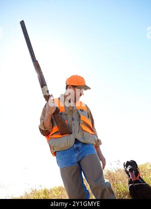 Homme, chien et en plein air pour les jeux de chasse, fusil et proie de traçage ensemble dans le Bush de la nature. Personne mature, animal de compagnie et chasseur soutien dans le champ à Banque D'Images