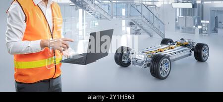 Ingénieur ou technicien asiatique travaillent avec la voiture ev en usine Banque D'Images