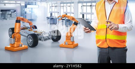 Ingénieur ou technicien asiatique travaillent avec la voiture ev en usine Banque D'Images