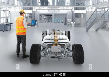 Ingénieur ou technicien asiatique travaillent avec la voiture ev en usine Banque D'Images