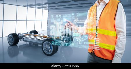 Ingénieur ou technicien asiatique travaillent avec la voiture ev en usine Banque D'Images