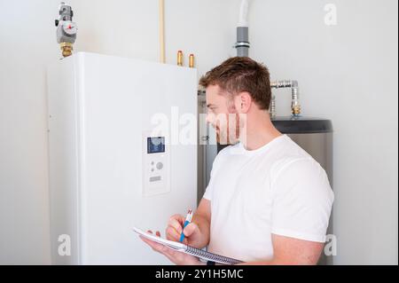 Le technicien vérifie le fonctionnement d'une pompe à chaleur dans une maison. Banque D'Images