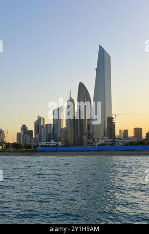 Vue de Koweït City dans une journée ensoleillée et coucher de soleil en arrière-plan. Banque D'Images