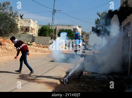 Les manifestants palestiniens affrontent les forces de sécurité israéliennes à la suite d'une manifestation hebdomadaire contre l'expropriation de terres palestiniennes par Israël dans le village de Kafr Qaddoum, près de Naplouse, en Cisjordanie. Au cours des affrontements, des adolescents palestiniens ont lancé de petites pierres sur les forces de sécurité israéliennes à l'aide d'une fronde Banque D'Images