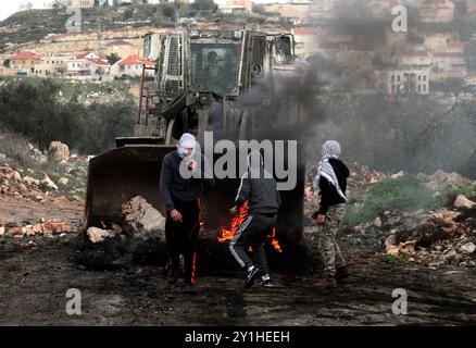 Des enfants et adolescents palestiniens affrontent des membres des forces de sécurité israéliennes à la suite d'une manifestation contre l'expansion de la colonie israélienne voisine de Qadomem, dans le village de Kafr Qaddum, en Cisjordanie, près de Naplouse Banque D'Images