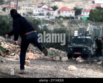 Des enfants et adolescents palestiniens affrontent des membres des forces de sécurité israéliennes à la suite d'une manifestation contre l'expansion de la colonie israélienne voisine de Qadomem, dans le village de Kafr Qaddum, en Cisjordanie, près de Naplouse Banque D'Images