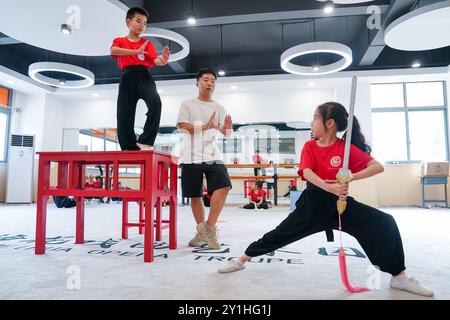 (240907) -- KUNSHAN, 7 septembre 2024 (Xinhua) -- Zhou Jie, enseignant à plein temps de la « classe de formation de l'Opéra de Little Kunqu », guide les élèves dans une salle de formation de l'école primaire Shipai Center de Kunshan dans la ville de Kunshan, province du Jiangsu, dans l'est de la Chine, 6 septembre 2024. Né en 1995 et élevé dans la ville de Kunshan, dans la province du Jiangsu de l'est de la Chine, Zhou Jie a rempli ses souvenirs d'enfance avec l'opéra de Kunqu à chaque festival et célébration. La ville de Kunshan est le lieu de naissance de l'Opéra de Kunqu, classé par l'Organisation des Nations Unies pour l'éducation, la science et la culture (UNESCO) comme immatériel Banque D'Images