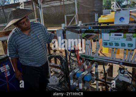 Malang, Java oriental, Indonésie. 7 septembre 2024. Un agriculteur montre l'équipement du système de technologie agricole de l'Internet des objets (IoT), une subvention du ministère indonésien de la communication et des technologies de l'information (Kemenkominfo), pour les plantes Melon Santaka dans une serre du village de Karangpandang, Malang, Java oriental, Indonésie, le 7 septembre, 2024. cette technologie agricole biologique et basée sur Internet. Faciliter les agriculteurs en Indonésie dans le processus d'entretien, de fertilisation et de lutte antiparasitaire qui est connecté par le téléphone portable de l'agriculteur. Ainsi que le maintien de la qualité de Banque D'Images