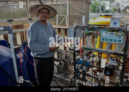 Malang, Java oriental, Indonésie. 7 septembre 2024. Un agriculteur montre l'équipement du système de technologie agricole de l'Internet des objets (IoT), une subvention du ministère indonésien de la communication et des technologies de l'information (Kemenkominfo), pour les plantes Melon Santaka dans une serre du village de Karangpandang, Malang, Java oriental, Indonésie, le 7 septembre, 2024. cette technologie agricole biologique et basée sur Internet. Faciliter les agriculteurs en Indonésie dans le processus d'entretien, de fertilisation et de lutte antiparasitaire qui est connecté par le téléphone portable de l'agriculteur. Ainsi que le maintien de la qualité de Banque D'Images