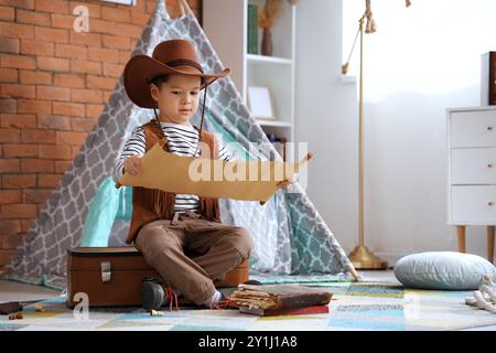 Mignon petit cow-boy avec carte au trésor à la maison Banque D'Images