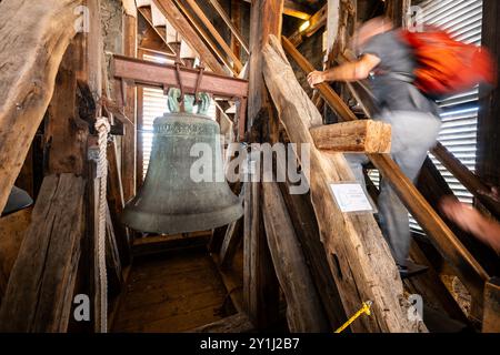 Erfurt, Allemagne. 07 septembre 2024. Un visiteur passe devant la cloche de l'église alors qu'il monte la tour de l'église d'un membre Egidien. Dix tours d'église à Erfurt ouvrent leurs portes lors de l'événement 'Erfordia turrita'. Crédit : Jacob Schröter/dpa/Alamy Live News Banque D'Images