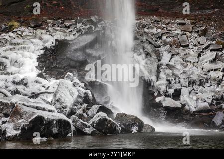 Les rochers à la base de Hardraw Force, la plus haute cascade d'Angleterre, sont recouverts de glace par une journée d'hiver enneigée en décembre Banque D'Images