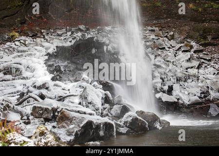 Les rochers à la base de Hardraw Force, la plus haute cascade d'Angleterre, sont recouverts de glace par une journée d'hiver enneigée en décembre Banque D'Images