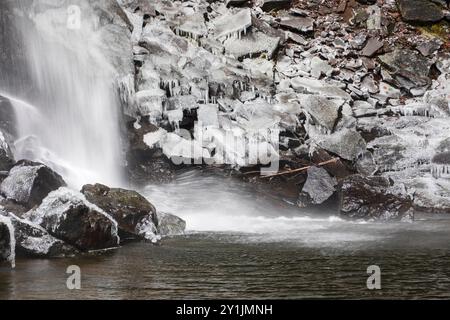 Les rochers à la base de Hardraw Force, la plus haute cascade d'Angleterre, sont recouverts de glace par une journée d'hiver enneigée en décembre Banque D'Images