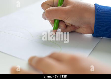 Enfant écrivant le mot allemand Buntstifte sur une feuille de papier. Banque D'Images